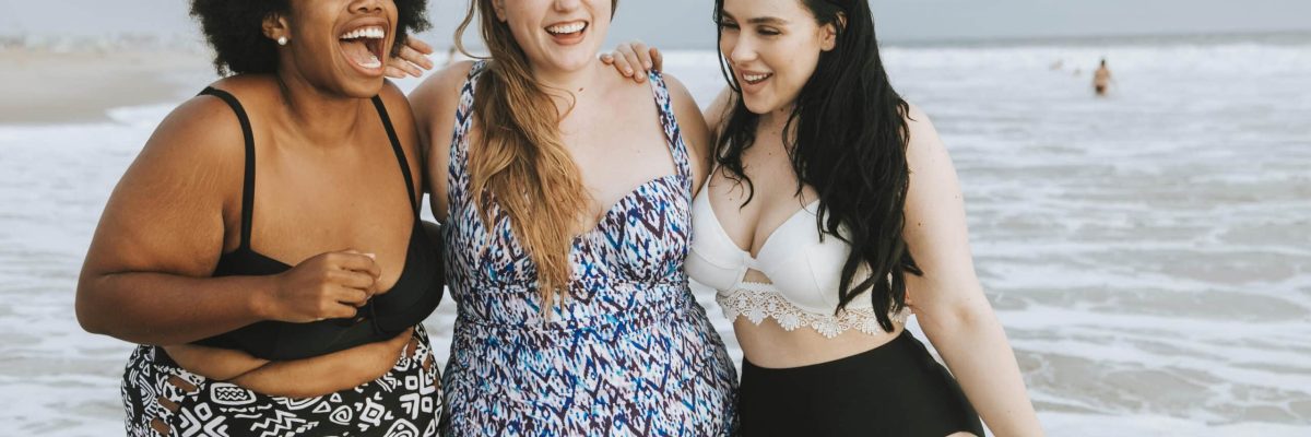 Cheerful plus size women enjoying the beach