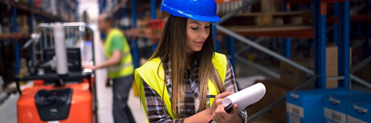 portrait-female-warehouse-worker-checking-inventory-storage-department-while-her-coworker-operating-forklift-background